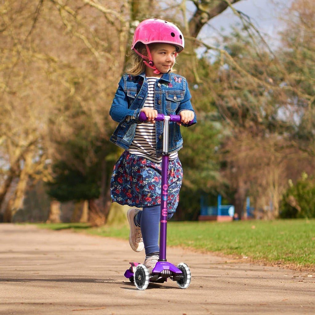 girl riding Micro Scooter Maxi Deluxe LED - Purple in park