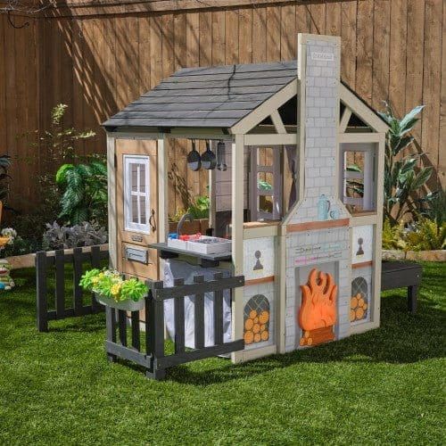 KidKraft Cozy Hearth Cabin Playhouse in garden