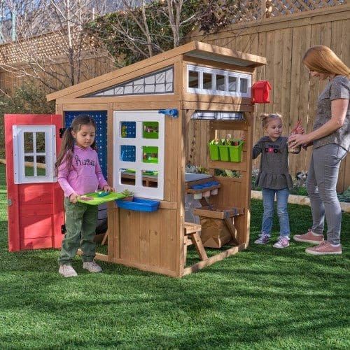woman and girls playing in KidKraft Hobby Workshop Wooden Playhouse 