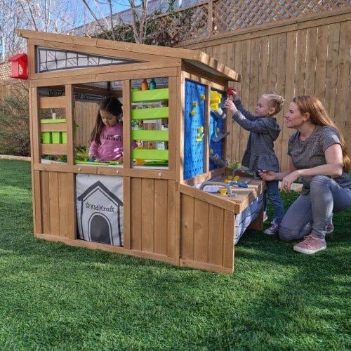 woman and children playing in KidKraft Hobby Workshop Wooden Playhouse 