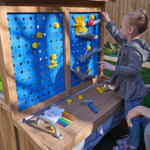 girl playing with gravity wall of KidKraft Hobby Workshop Wooden Playhouse 