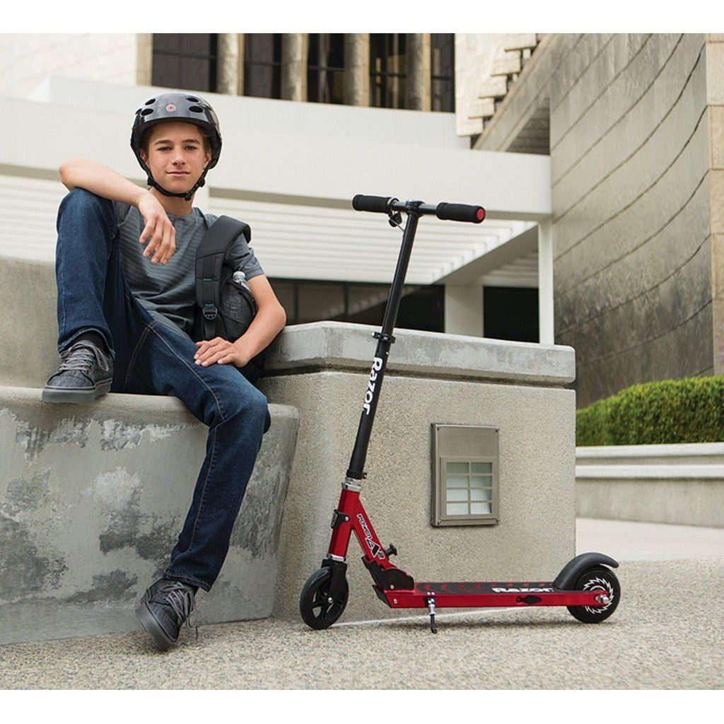boy on step next to Razor Power A2 Scooter 22 Volt Scooter