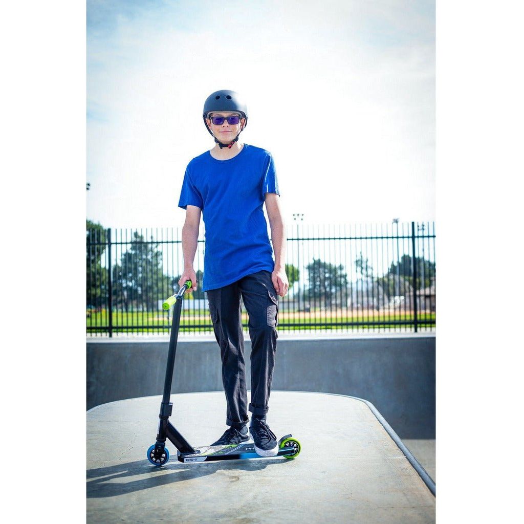 boy in helmt with one foot on Razor Pro-X Scooter in skate park