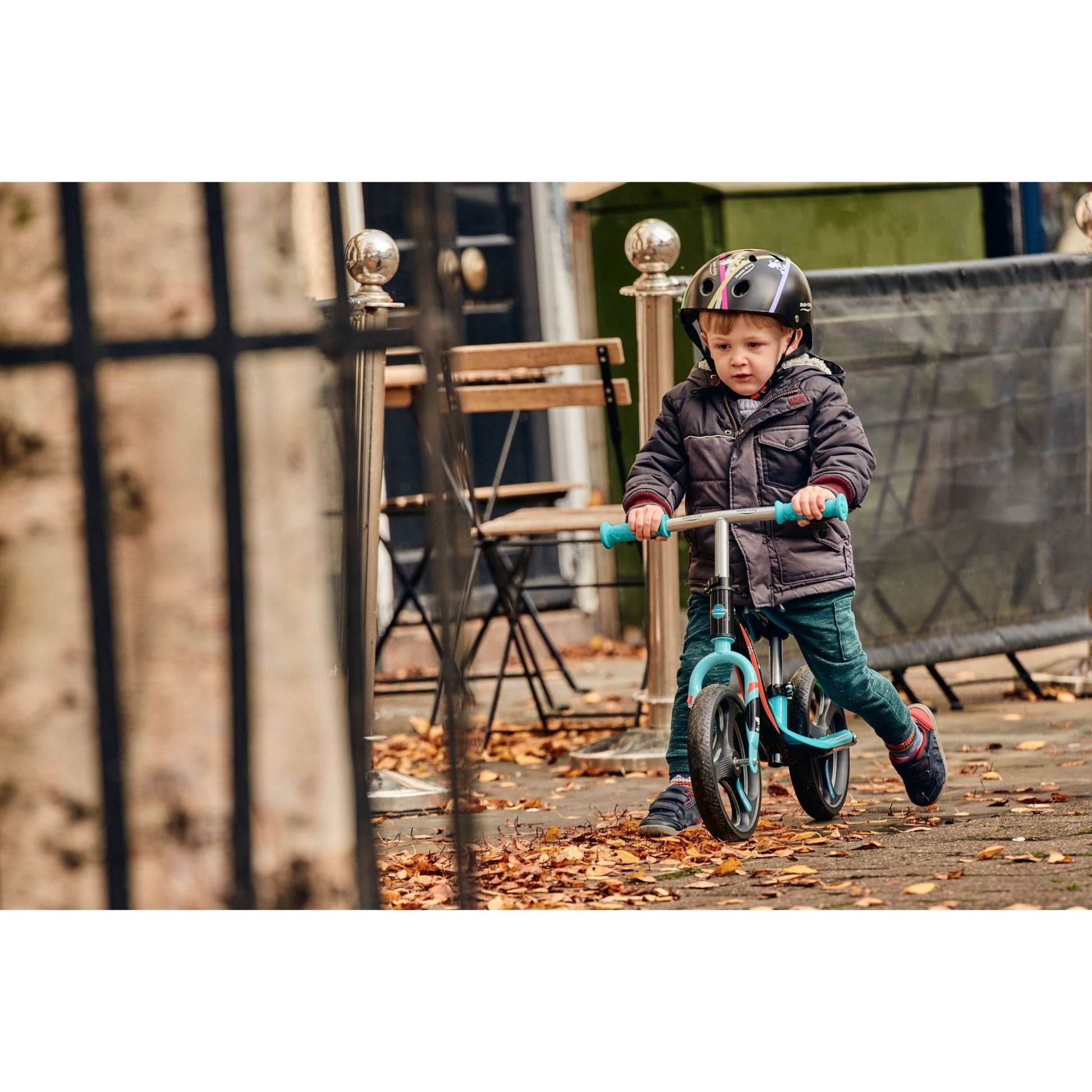 boy riding Ride-Ezy Go Glo Balance Bike - Black & Celeste Green on pavement close up