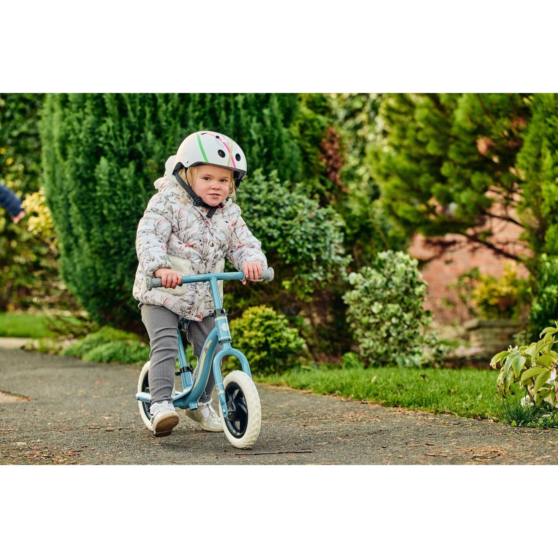 girl riding Ride-Ezy Go Balance Bike - Blue & Silver on pavement