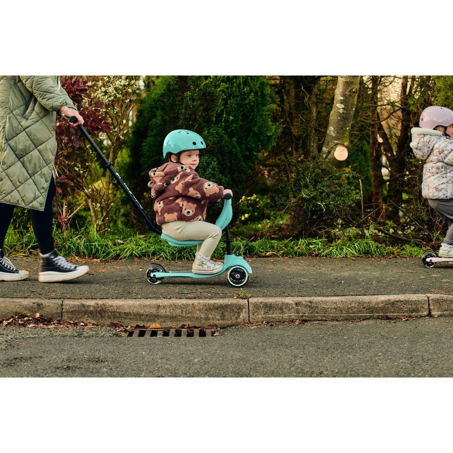 girl sitting on ride-ezy kick scooter while wearing Ride-Ezy Hector 48-53cms Kids Helmet - Kingfisher