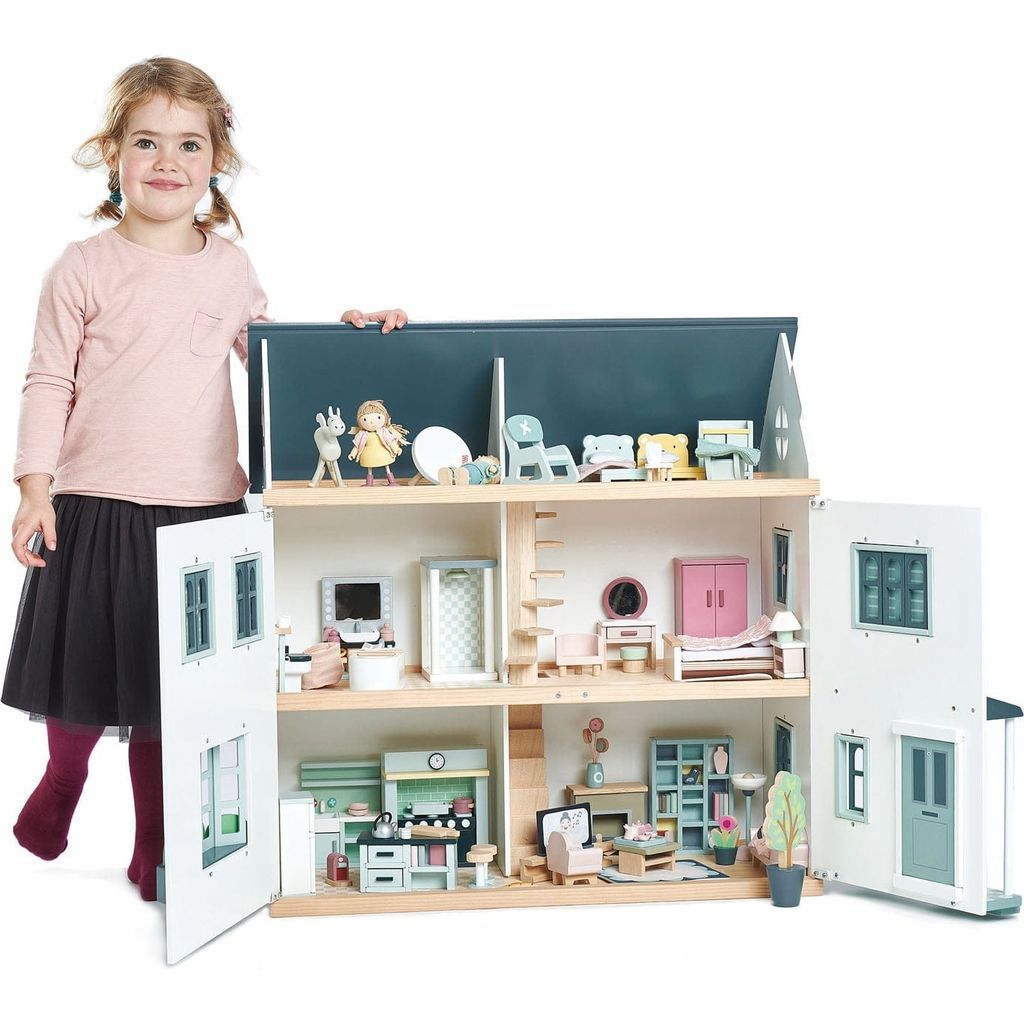 girl standing with wooden dolls house and Tender Leaf Dolls House Bedroom Furniture