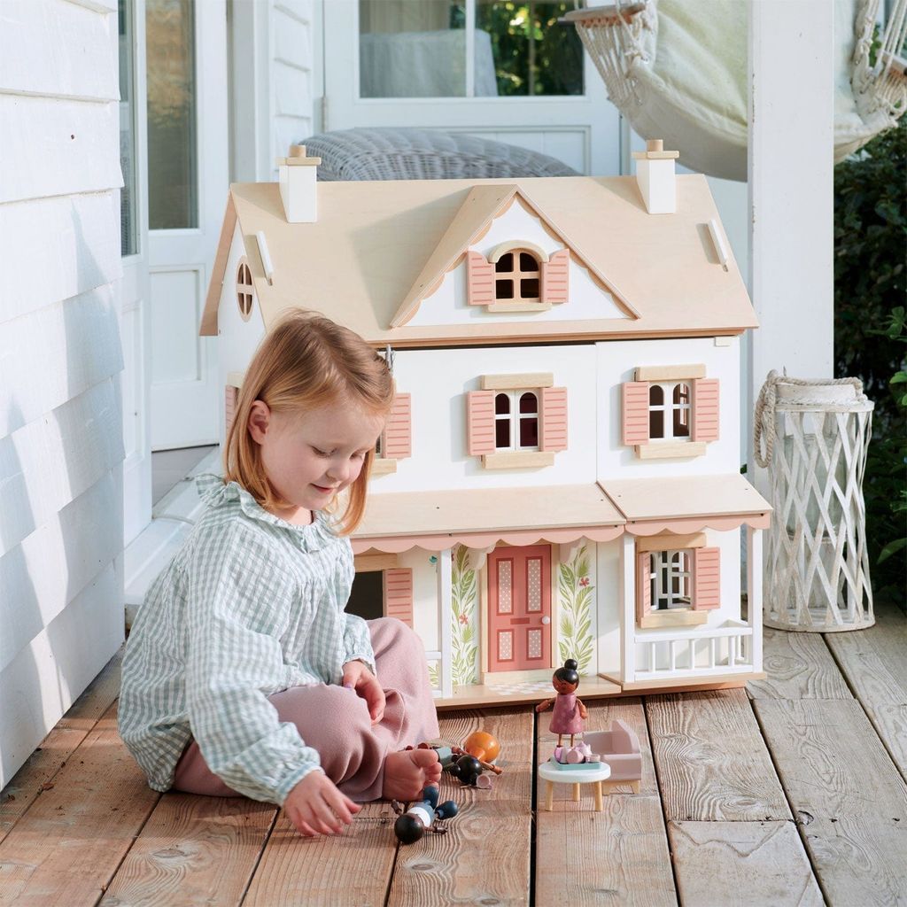 girl sitting in front of Tender Leaf Hummingbird Wooden Doll House