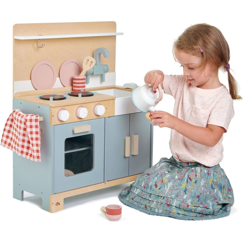girl pouring kettle from Tender Leaf Home Wooden Play Kitchen