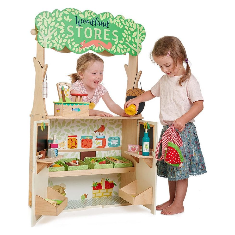 2 girls playing with store of the Tender Leaf Woodland Stores & Theatre wooden toy 
