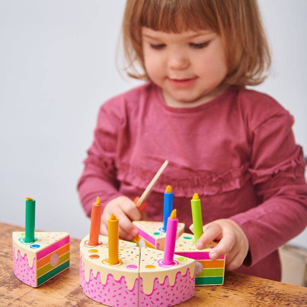 girl playing with wooden cake from Tender Leaf Rainbow Cake & Lolly Shop Wooden Toy Bundle