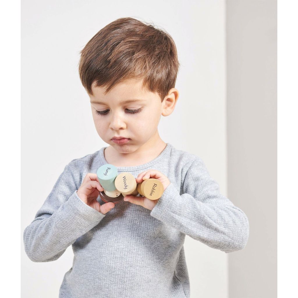 boy holding figures from Tender Leaf Timber Taxi Wooden Toy
