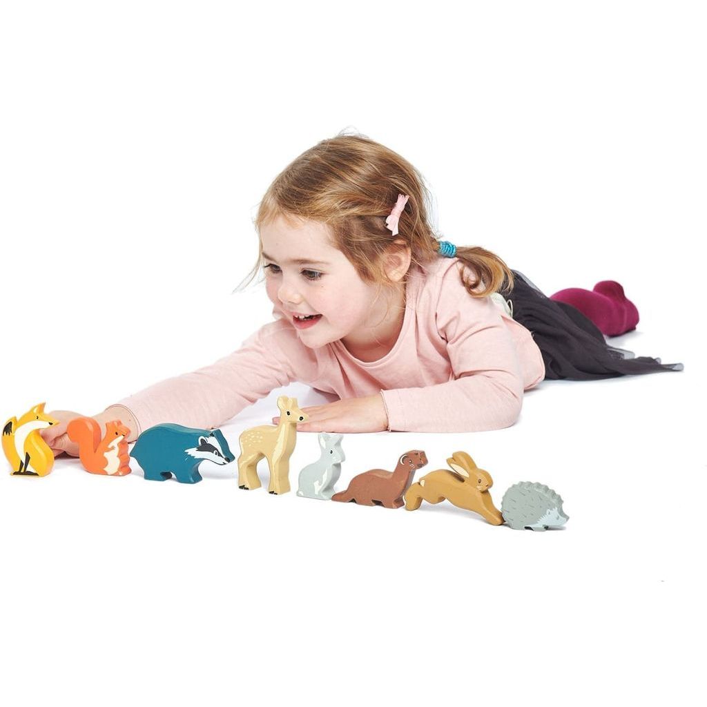 girl lying on floor playing with Tender Leaf 8 Wooden Woodland Animals Toys & Shelf 