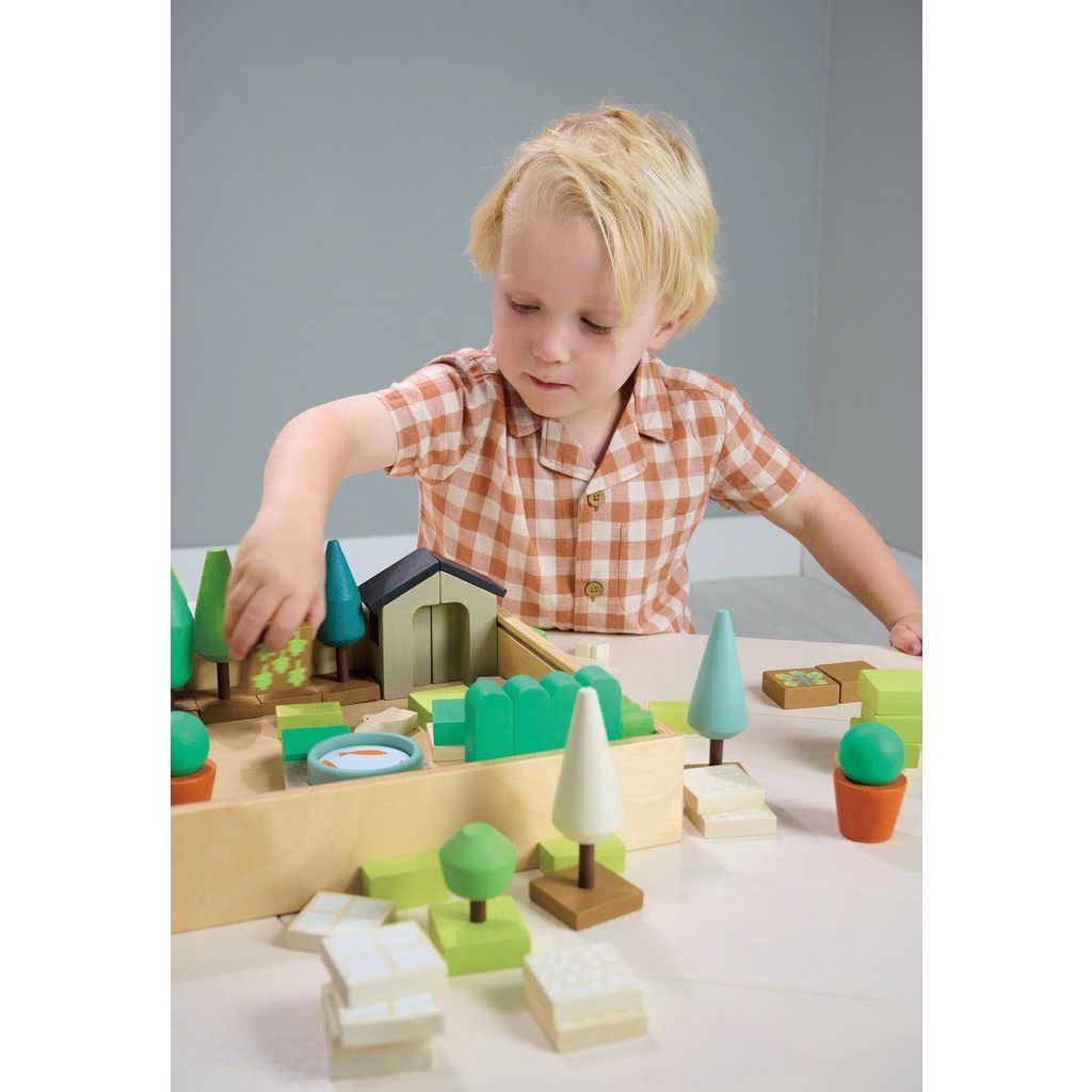 blonde boy playing with Tender Leaf Little Garden Designer Wooden Toy