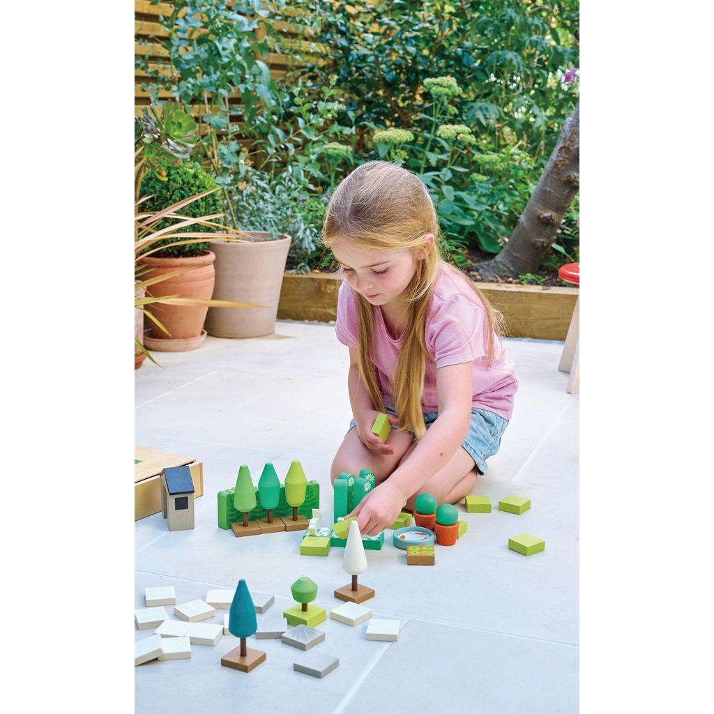 girl on patio playing Tender Leaf Little Garden Designer Wooden Toy