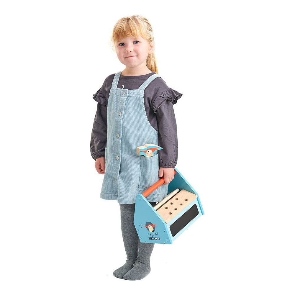 girl standing and holding Tender Leaf Tap Tap Wooden Tool Box