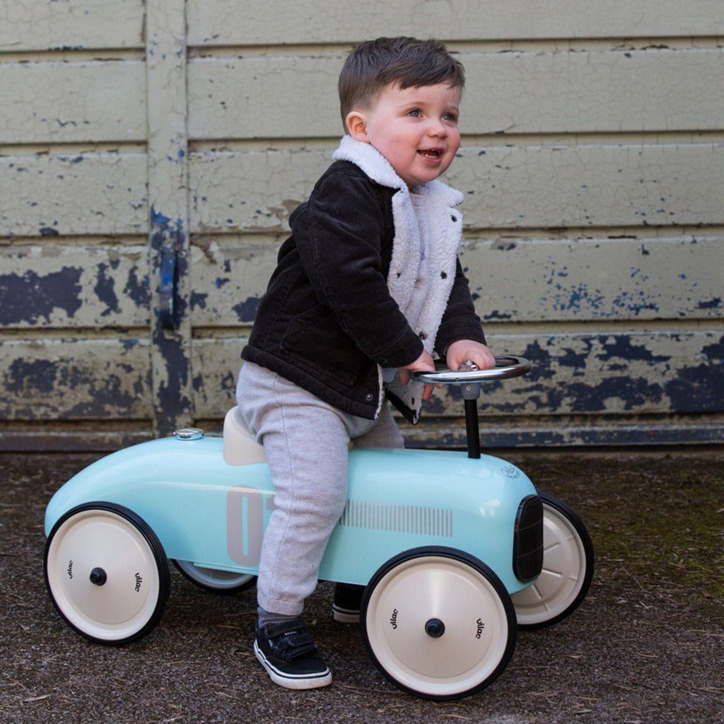 little boy riding Vilac Classic Ride-On Racing Car - 18m+ - Light Blue