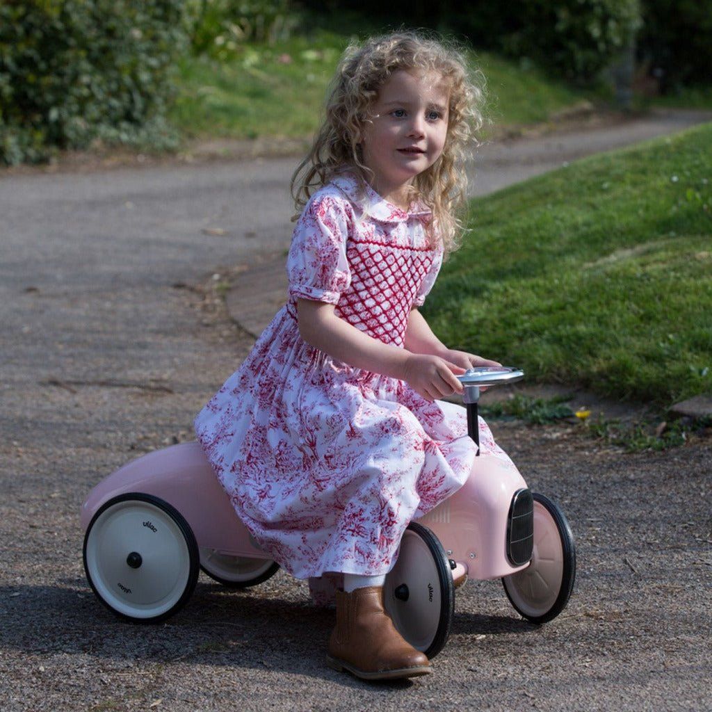 little girl riding Vilac Classic Ride-On Racing Car - 18m+ - Pink