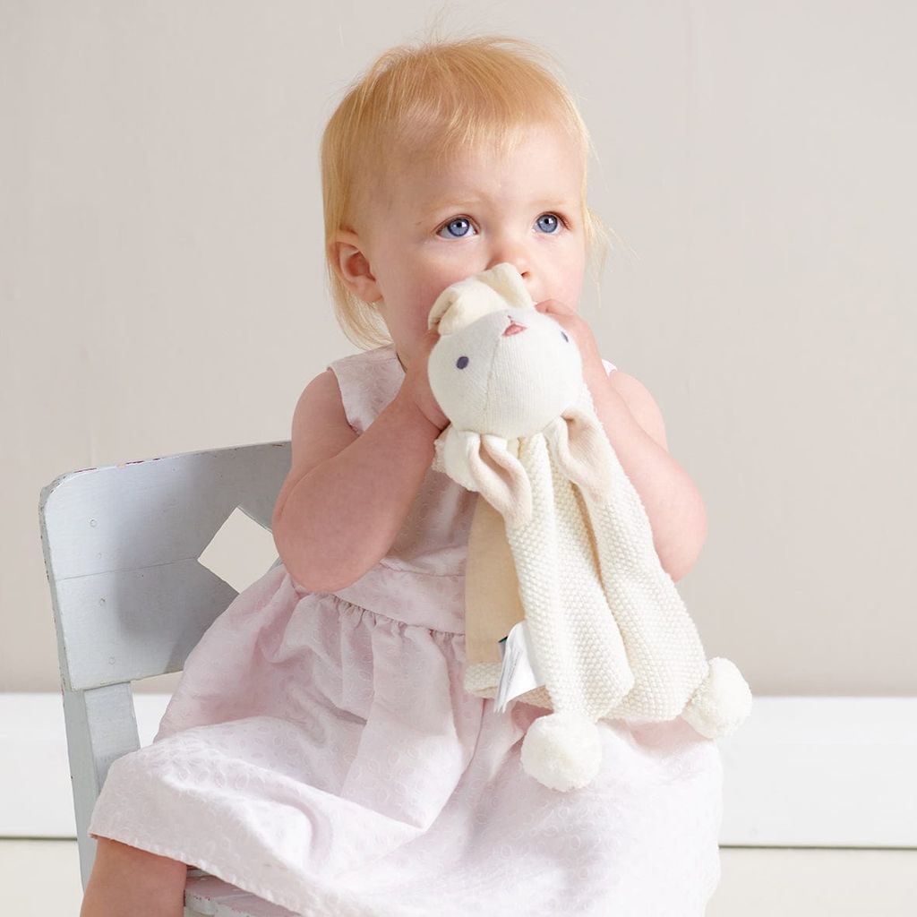 baby holding conforter from ThreadBear Baby Comforter, Rattle & Doll Bundle in Cream