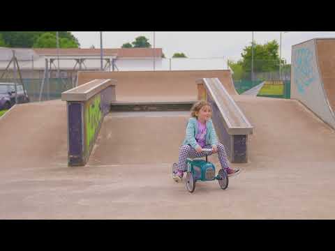 little girl riding vilac racing car in skate park