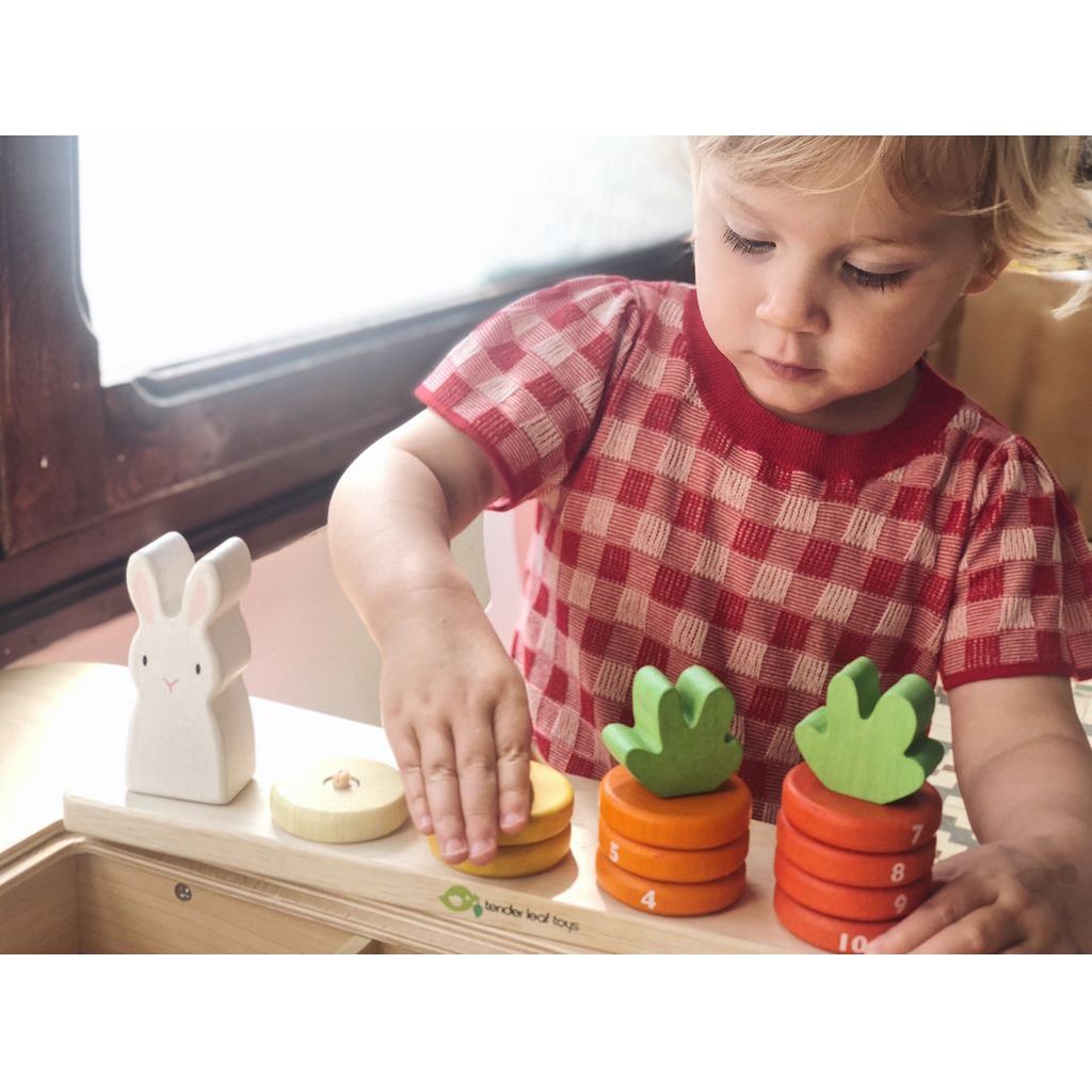 close up of child playing with Tender Leaf Counting Carrots Wooden Counting Game