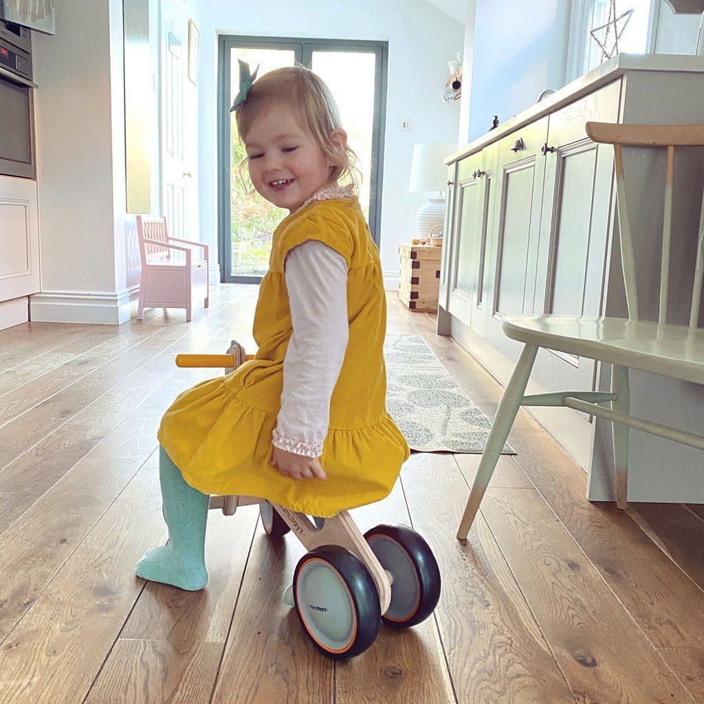 little girl riding Mama Toyz Wooden Mini Bike Age 15 Months + inside