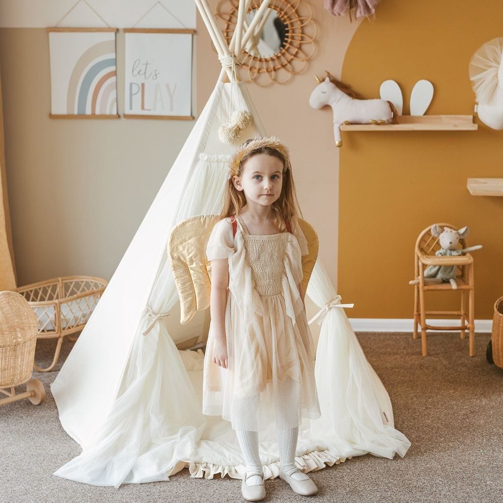 girl in white dress and wings standing in front of MINICAMP Fairy Kids Play Tent With Tulle in Ecru