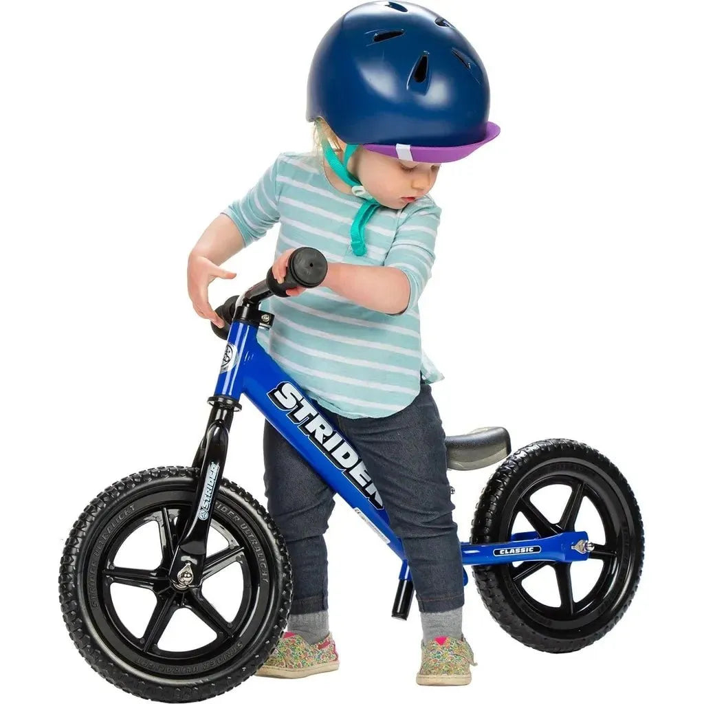 boy in helmet riding Strider Classic 12 inch Balance Bike - Blue
