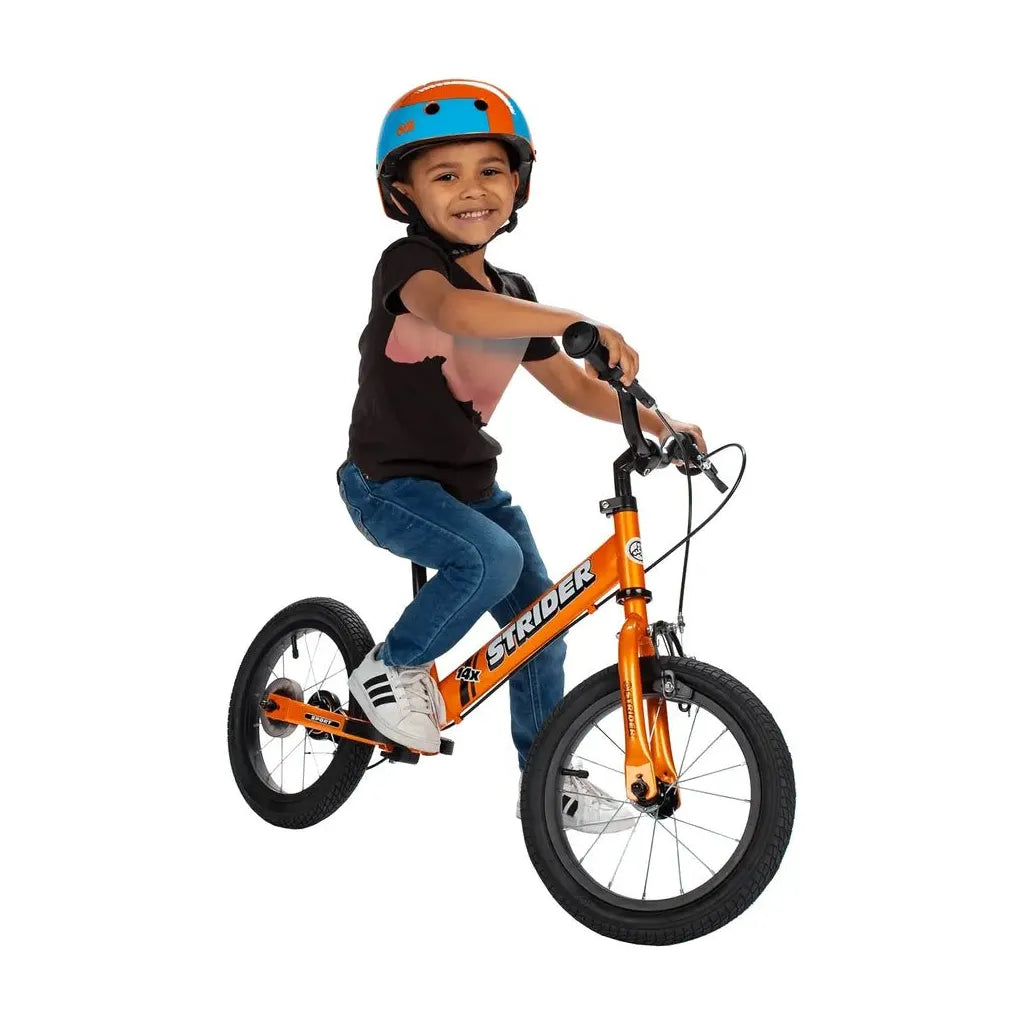 smiling boy riding Strider 14x Balance Bike - Tangerine