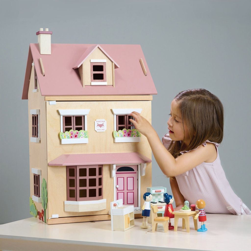 girl playing with Tender Leaf Wooden Doll House Foxtail Villa + Furniture