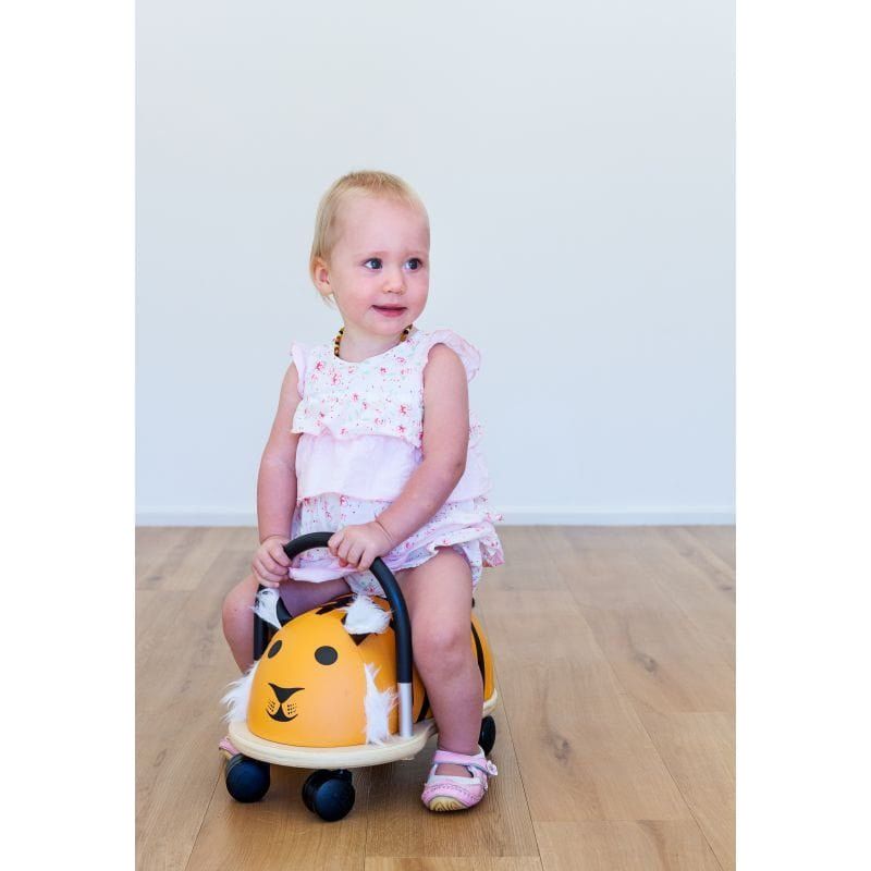 little girl sitting on Wheelybug Ride On - Tiger