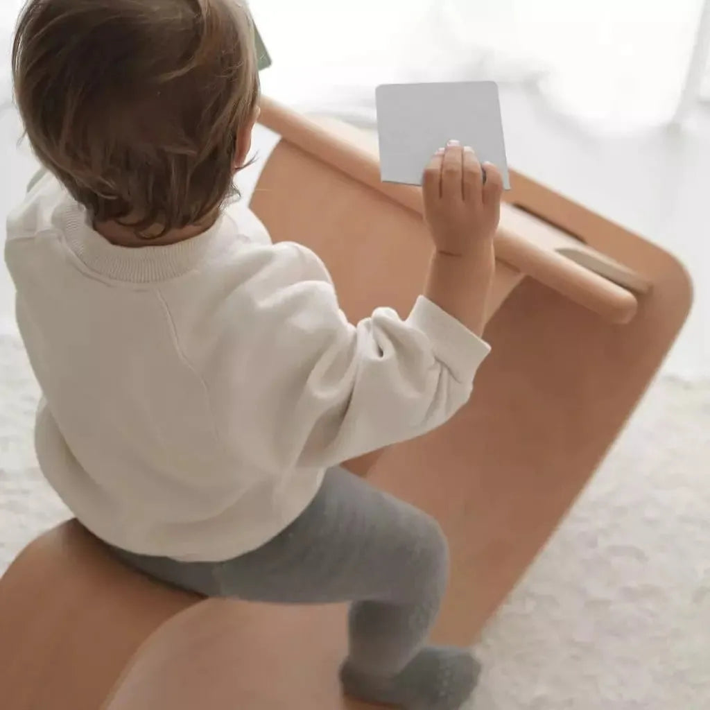 child sitting on Curve Lab Rocking Horse & Perfect Arc Balance Board